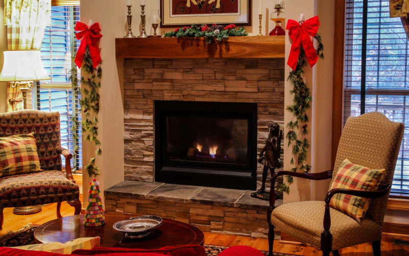 fireplace, mantel, living room, cozy, christmas, xmas, chairs, seating, stone fireplace, family room, decorations, pine garland, holiday, interior design