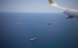 aerial view, cargo ships, ocean, airplane window, aircraft wing, fame, airplane, ships, sky, wing, aircraft, bird view, cargo, carrier, sea, shipment, shipping, trade, transportation, travel, vessels, water, vehicles, flying